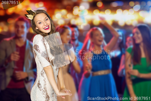 Image of happy young woman in crown at night club party 
