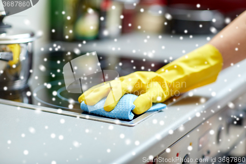 Image of close up of woman cleaning cooker at home kitchen