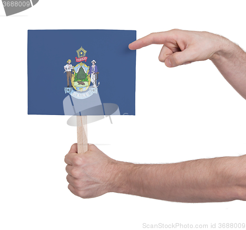 Image of Hand holding small card - Flag of Maine
