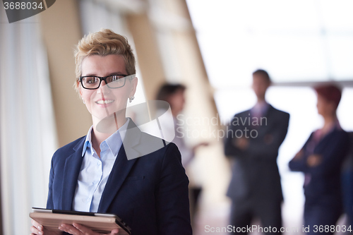 Image of business woman  at office with tablet  in front  as team leader