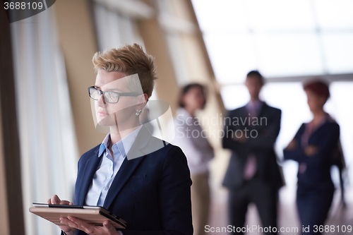 Image of business woman  at office with tablet  in front  as team leader