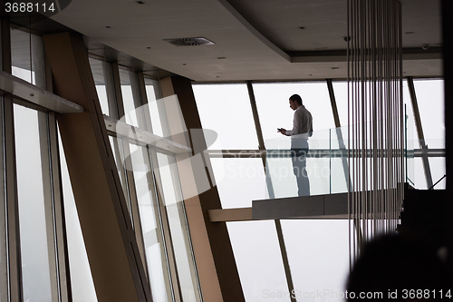 Image of young successful business man in penthouse apartment working on 