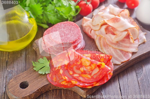 Image of sausages,ham and salami on board