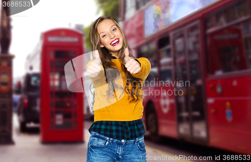 Image of happy young woman or teen girl showing thumbs up