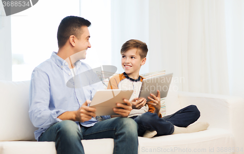 Image of happy father and son with tablet pc at home