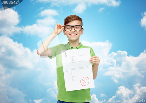 Image of happy boy in eyeglasses holding school test result