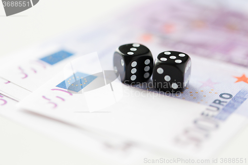 Image of close up of black dice and euro cash money