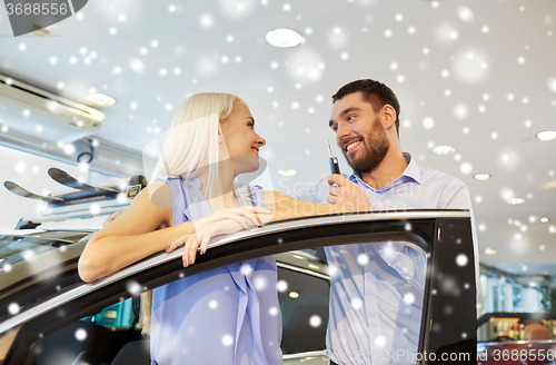 Image of happy couple buying car in auto show or salon