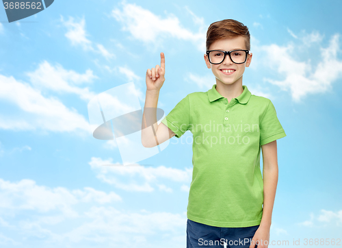 Image of happy boy in eyeglasses pointing finger up