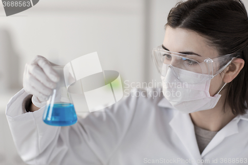 Image of close up of scientist with flask making test