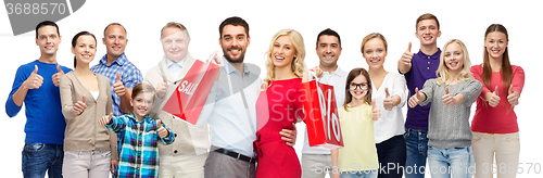 Image of happy people with shopping bags showing thumbs up