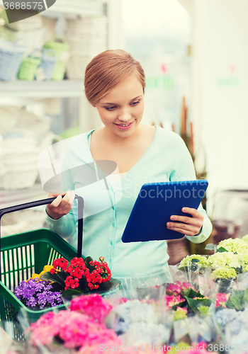 Image of woman with tablet pc and basket at flower shop