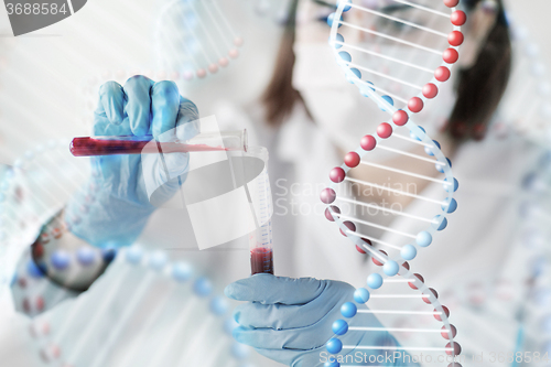 Image of close up of scientist with tube making test in lab