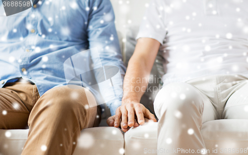 Image of close up of happy male gay couple holding hands