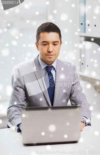 Image of businessman working with laptop in office