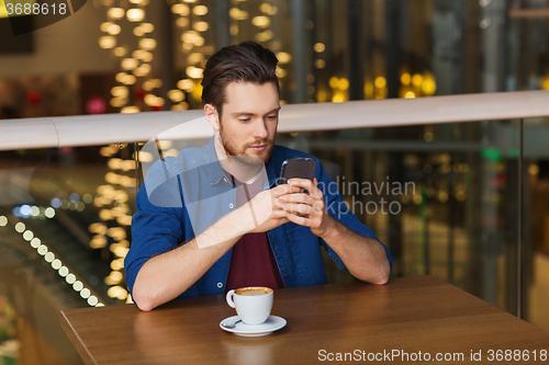 Image of man with smartphone and coffee at restaurant