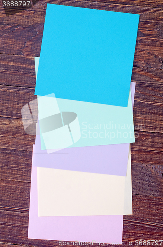 Image of color paper on wooden background