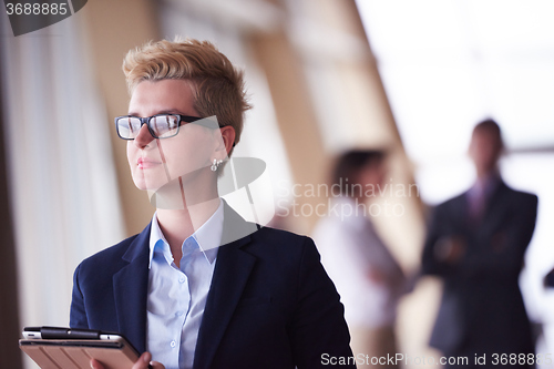 Image of business woman  at office with tablet  in front  as team leader