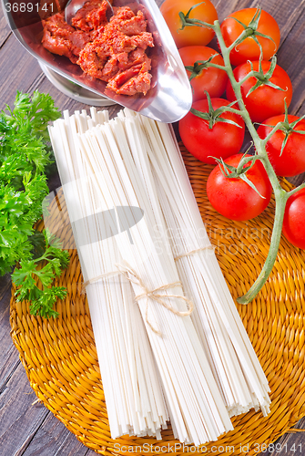 Image of raw pasta and  tomato and sauce