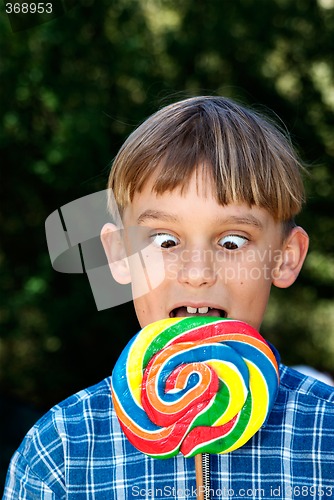 Image of cross eyed boy eating lollipop