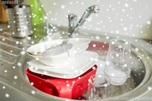 Image of close up of dirty dishes washing in kitchen sink