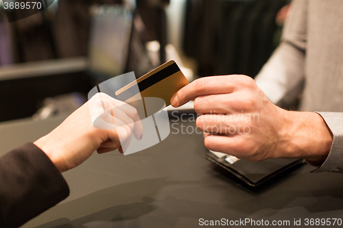 Image of close up of hand giving credit card to seller