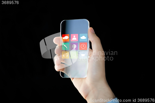 Image of close up of male hand with transparent smartphone