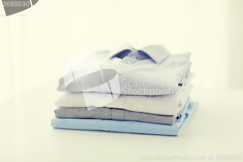 Image of close up of ironed and folded shirts on table