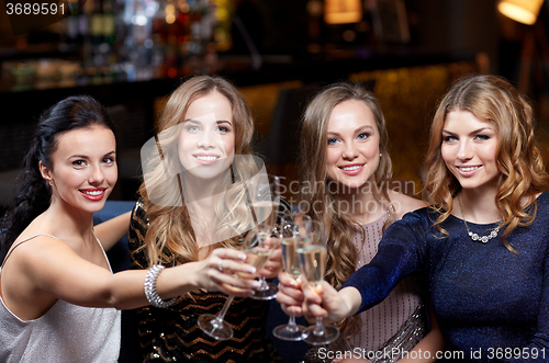 Image of happy women with champagne glasses at night club