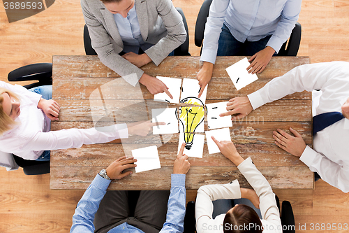 Image of close up of business team with light bulb puzzle