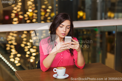 Image of woman with smartphone and coffee at restaurant