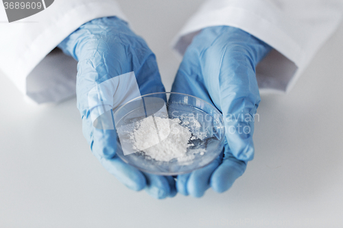 Image of close up of scientist holding petri dish in lab