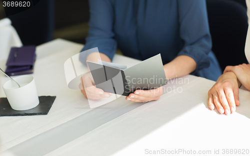 Image of close up of woman hands holding restaurant bill