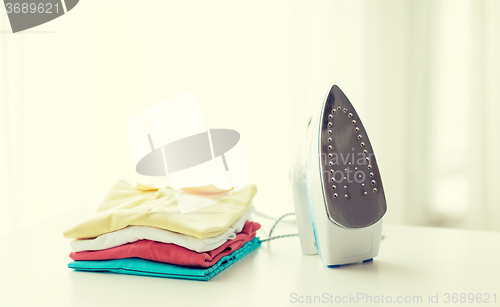 Image of close up of iron and clothes on table at home