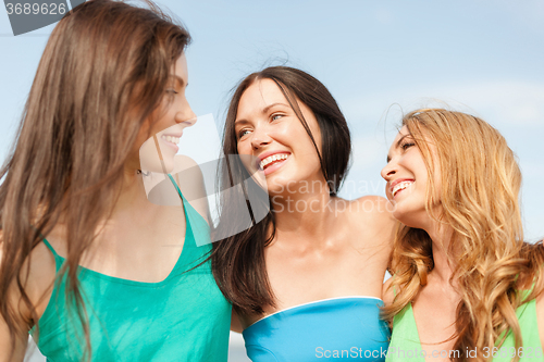 Image of smiling girls walking on the beach