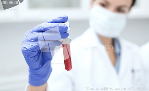 Image of close up of scientist holding test tube in lab