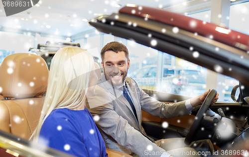 Image of happy couple buying car in auto show or salon