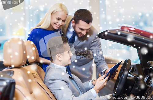 Image of happy couple with car dealer in auto show or salon