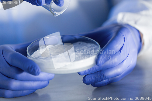 Image of close up of scientists hands with chemicals in lab