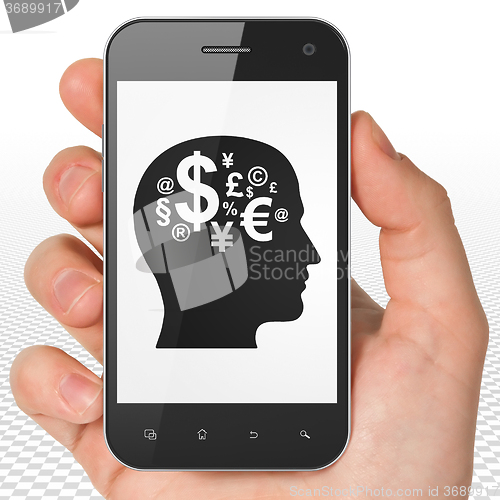 Image of Business concept: Hand Holding Smartphone with Head With Finance Symbol on display
