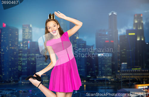Image of happy young woman in crown over night city