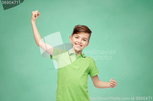 Image of happy school boy in t-shirt showing strong fists
