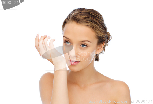 Image of woman smelling perfume from wrist of her hand