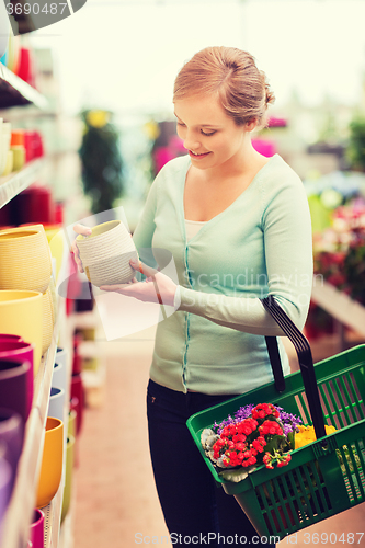 Image of woman with shopping basket choosing flowerpot