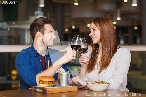 Image of happy couple dining and drink wine at restaurant
