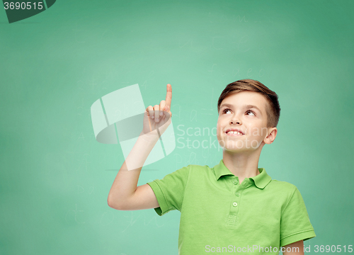 Image of happy boy in green polo t-shirt pointing finger up