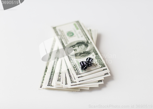 Image of close up of black dice and dollar cash money