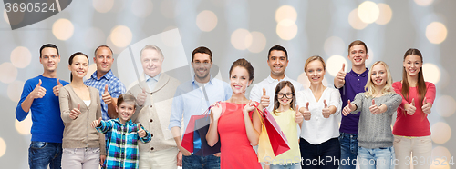 Image of happy people with shopping bags showing thumbs up