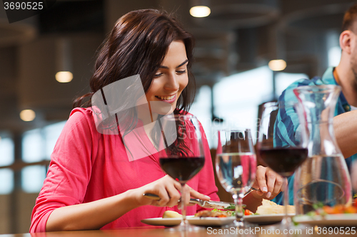 Image of happy woman having dinner at restaurant