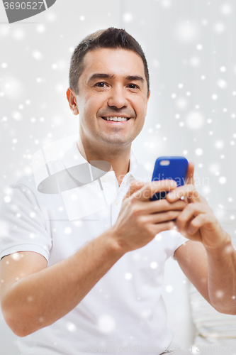Image of happy man with smartphone at home